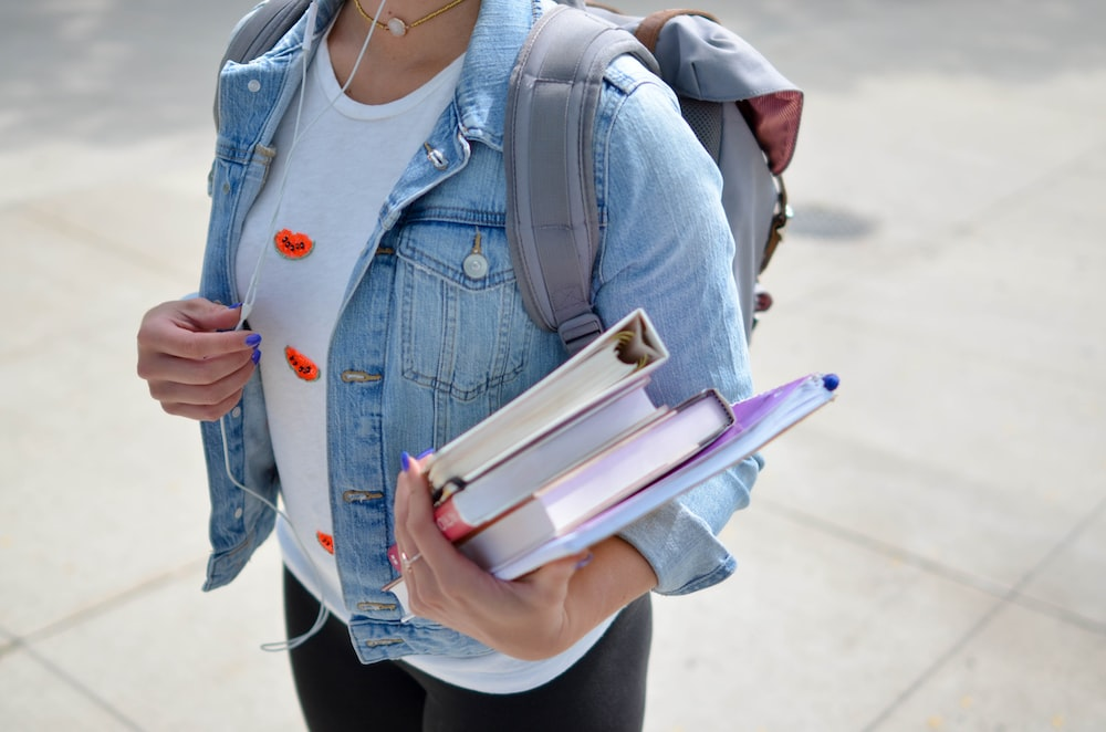 A student with a backpack and a set of books