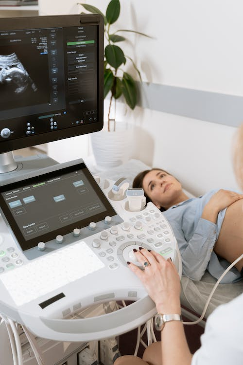 A doctor conducting an ultrasound scan on an expecting mother