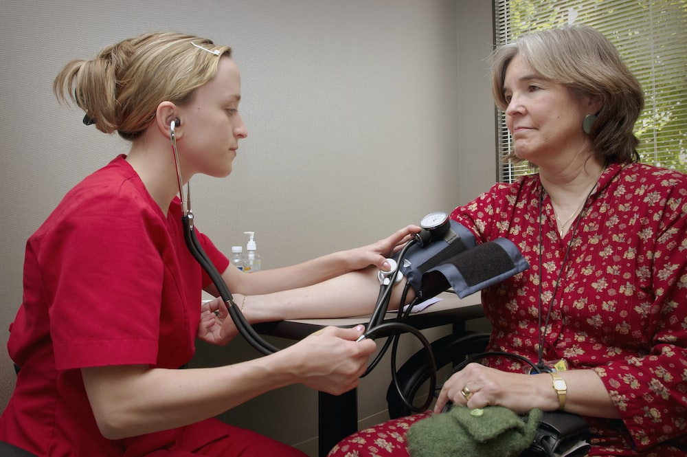 A nurse checking a woman’s blood pressure