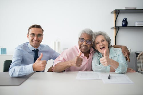 An old couple sitting next to an insurance agent